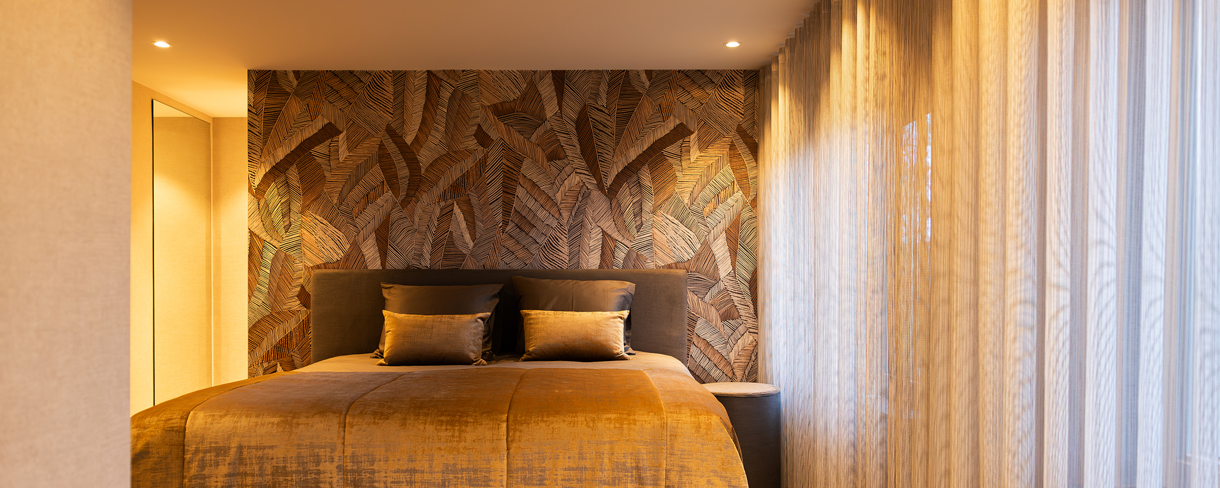 Sfeervolle slaapkamer met design behang van Arte en maatwerk bedsprei